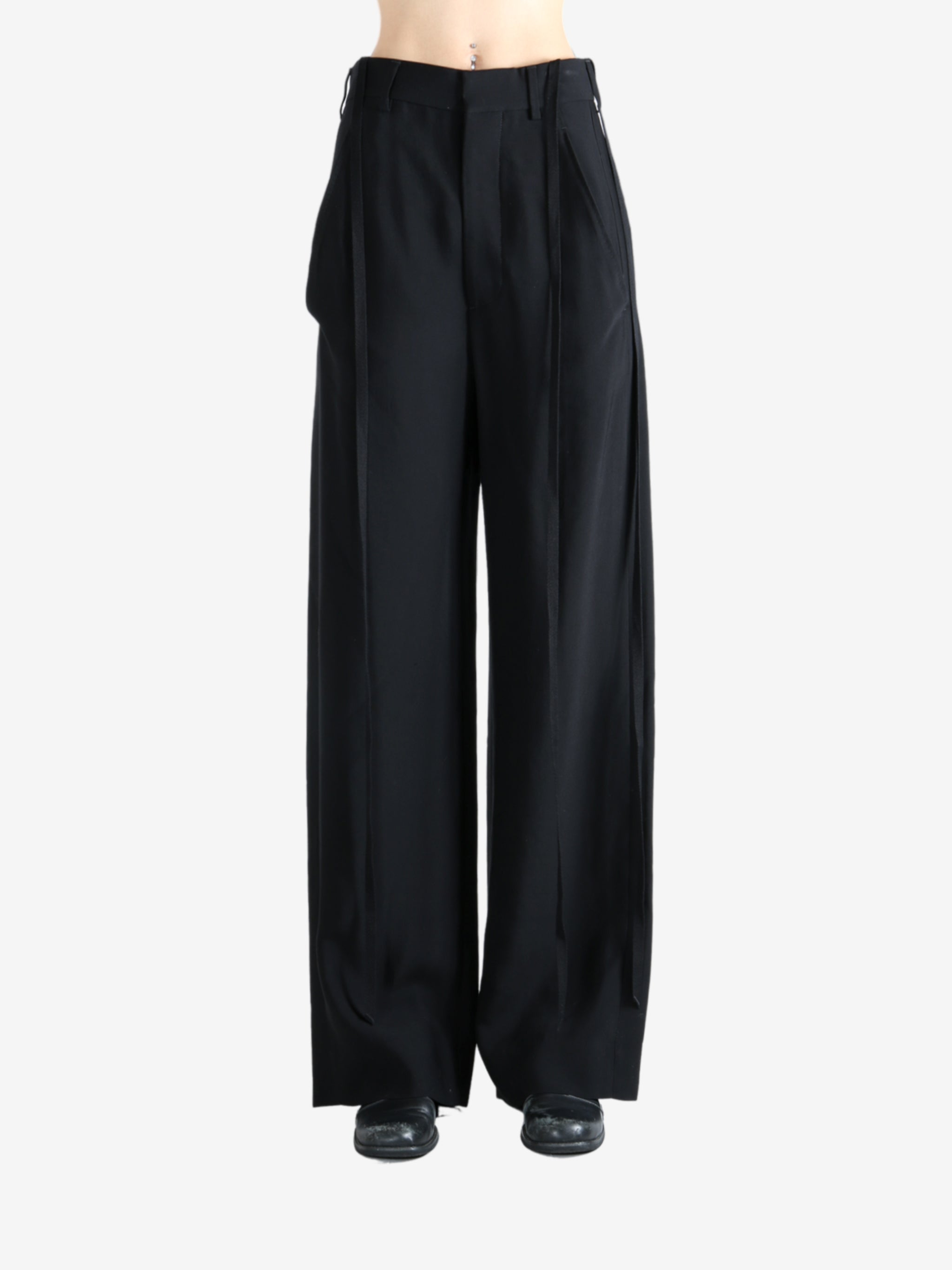 Black pants worn by a person, showing the pants' fit