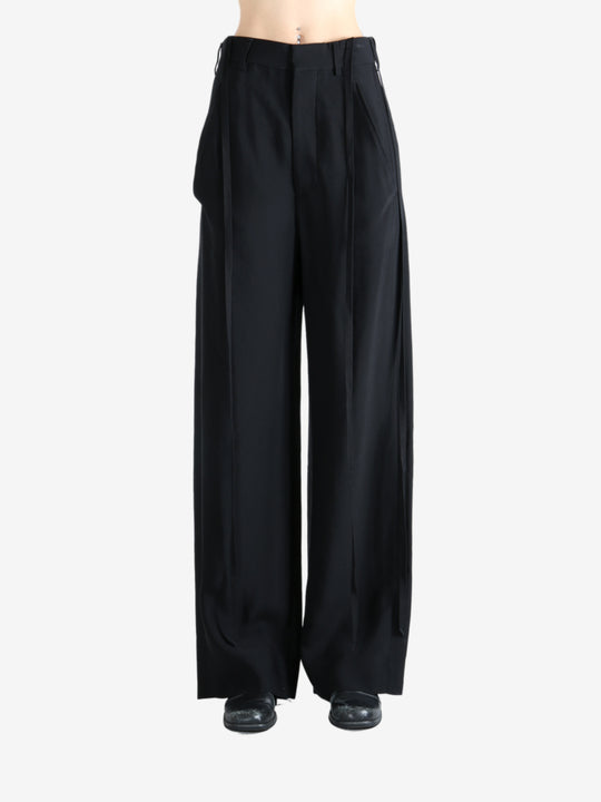 Black pants worn by a person, showing the pants' fit