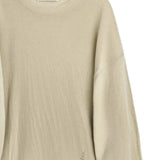 Close up of tan knitwear, showing texture of the merino wool fabric