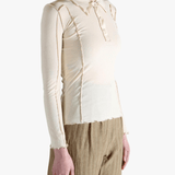 White top worn by a person,showing the top fit