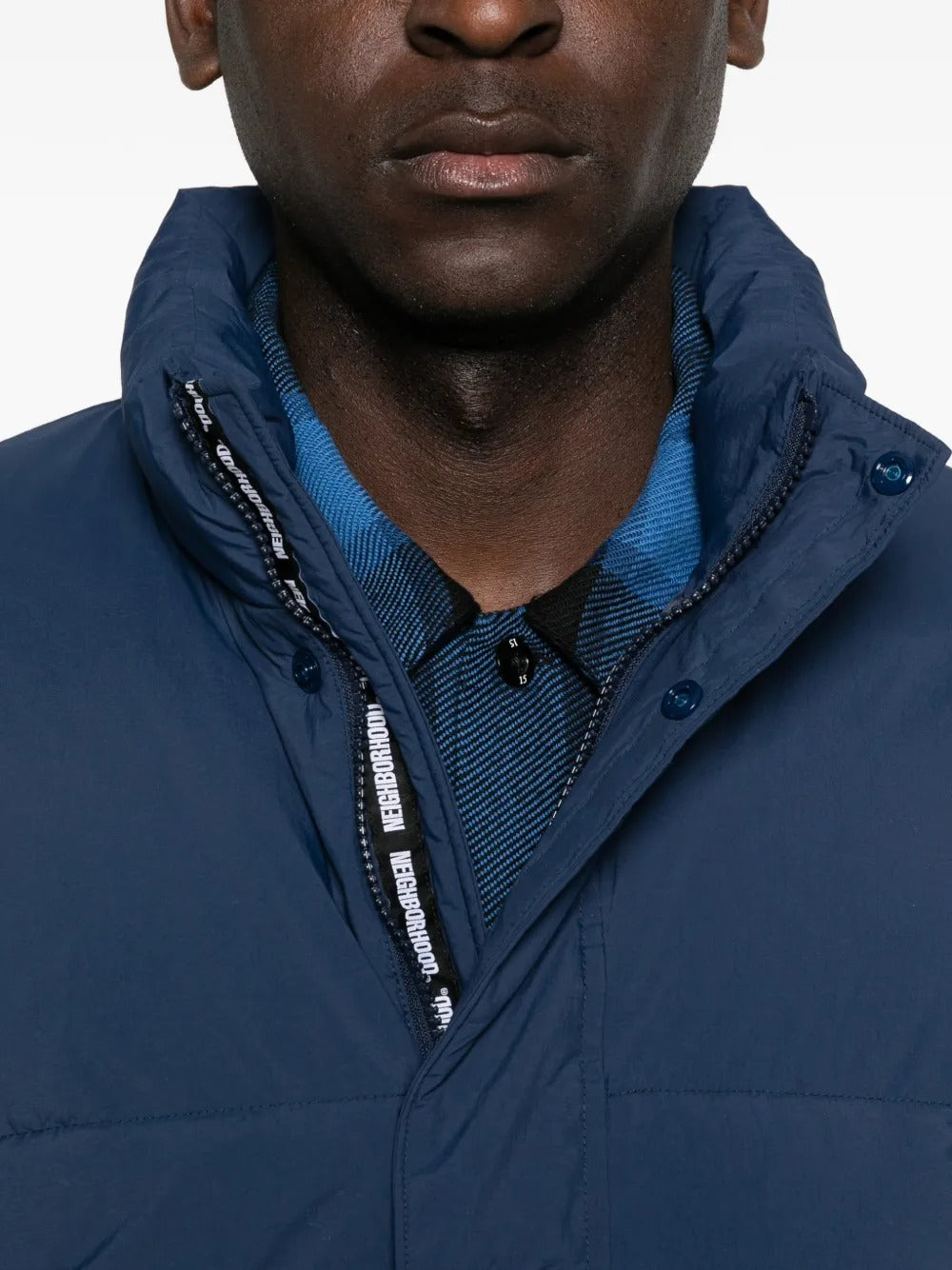 Close up of navy jackets, showing texture of the nylon and polyester and down and feather fabric