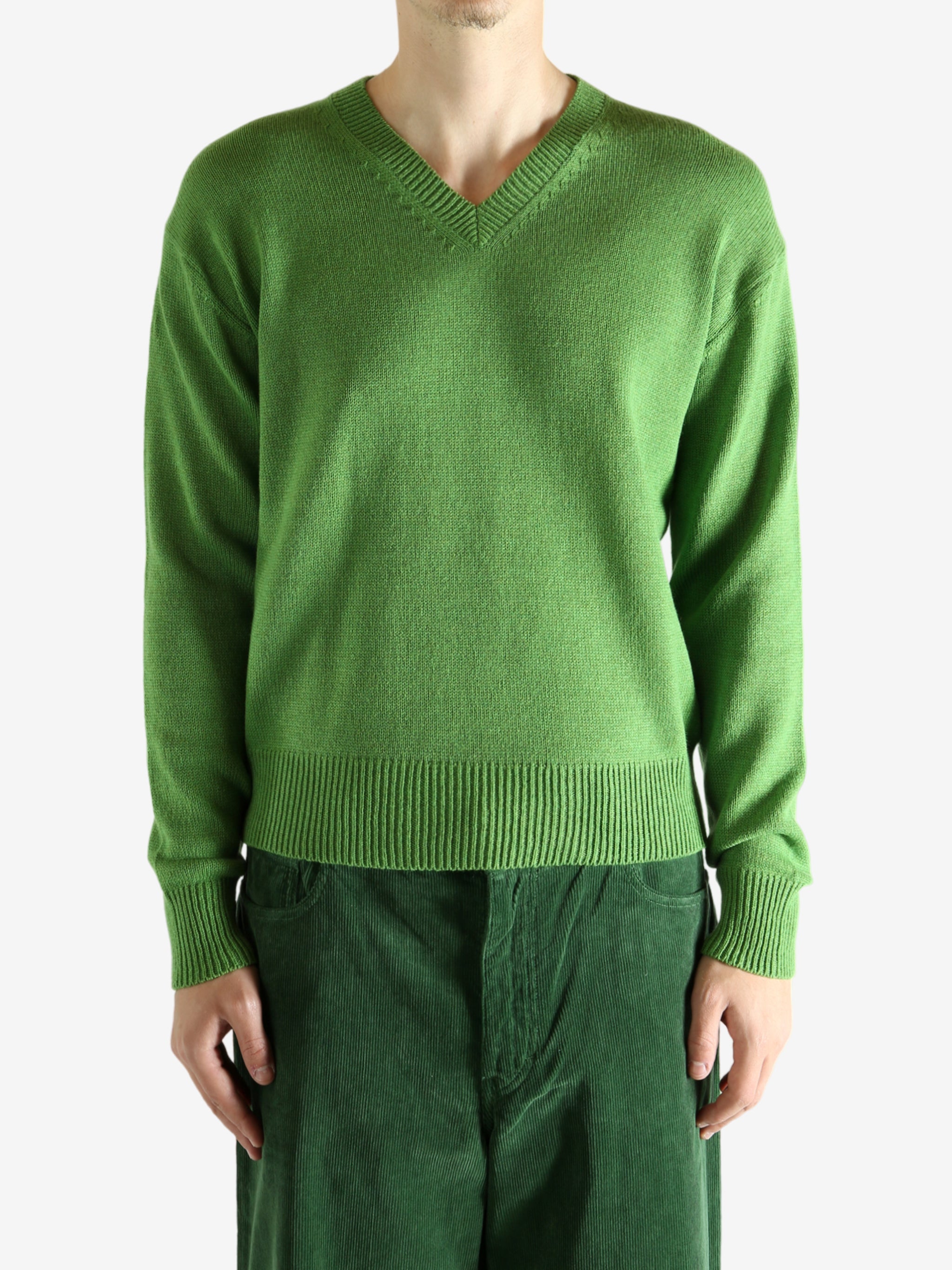 Green knitwear worn by a person, showing the knitwear's fit