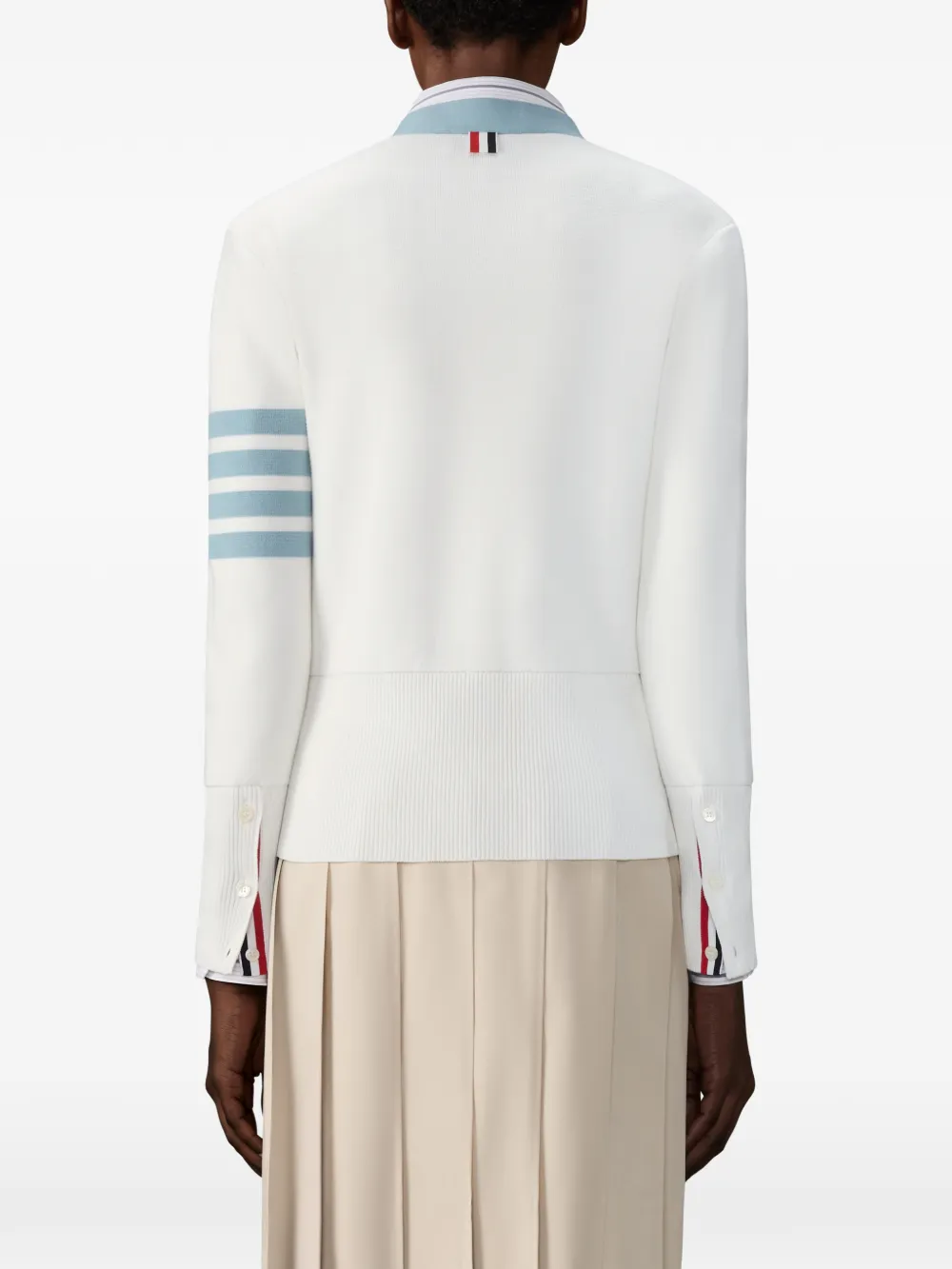 White cardigan worn by a person, showing the cardigan fit