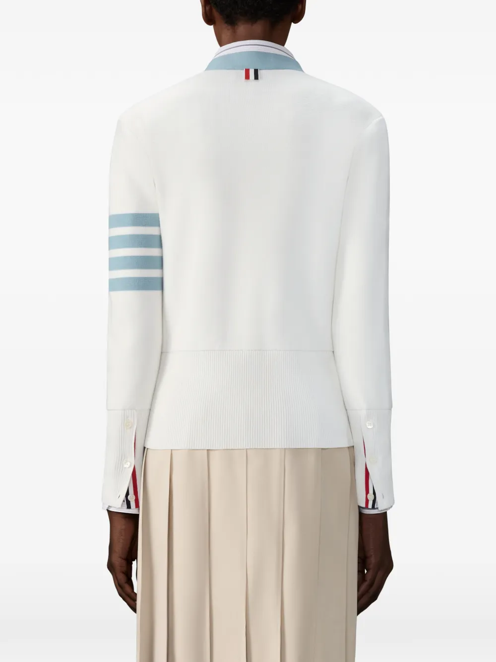 White cardigan worn by a person, showing the cardigan fit