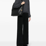 Black bag carried by a person, showing the bag’s fit