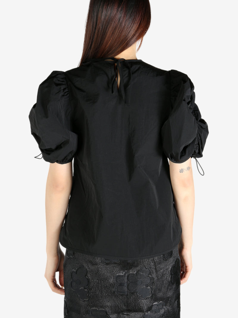 Black top worn by a person, showing the top’s fit