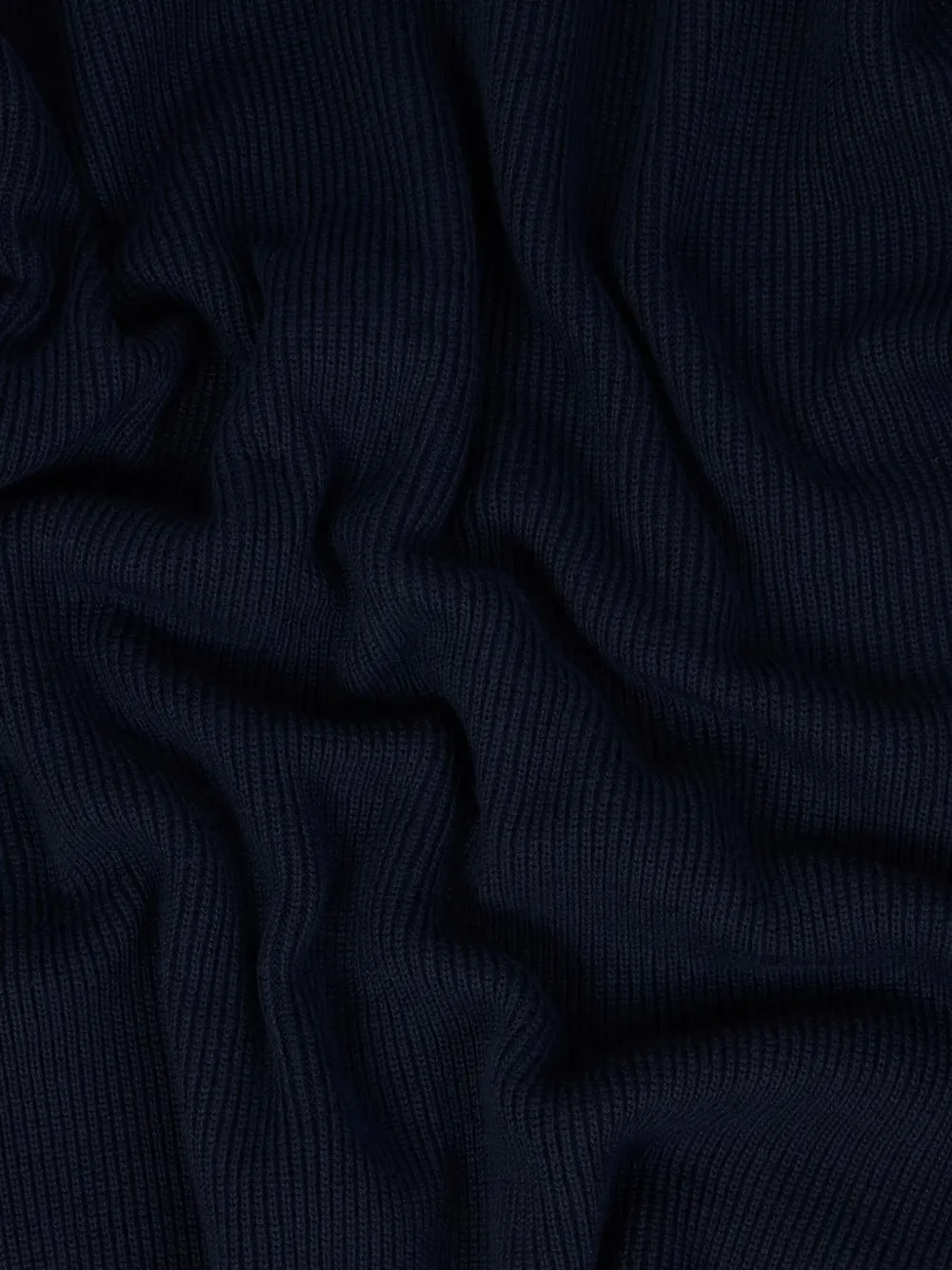 Close up of black polo shirt, showing texture of the cotton fabric