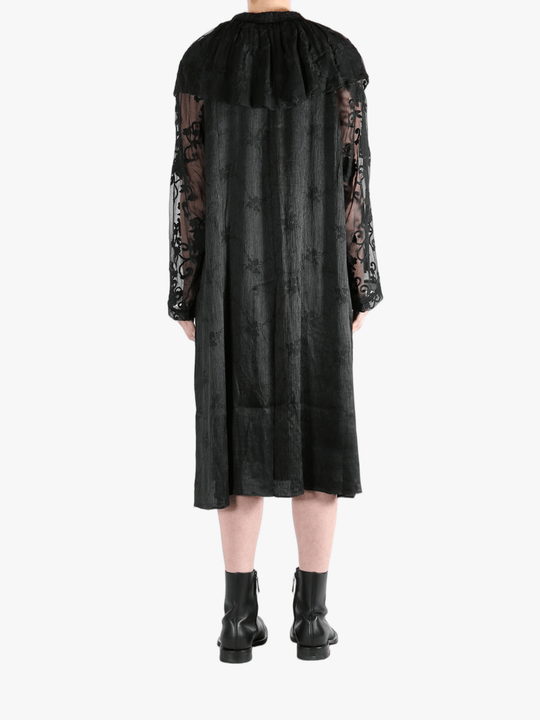 Black coats worn by a person, showing the coat's fit