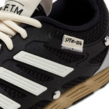 Close up of the black sneakers, showing texture of the rubber fabric