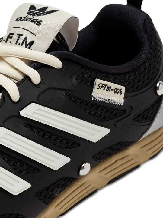 Close up of the black sneakers, showing texture of the rubber fabric
