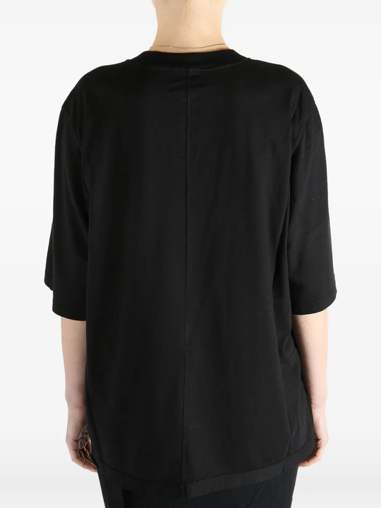 Black t-shirt worn by a person, showing the fit