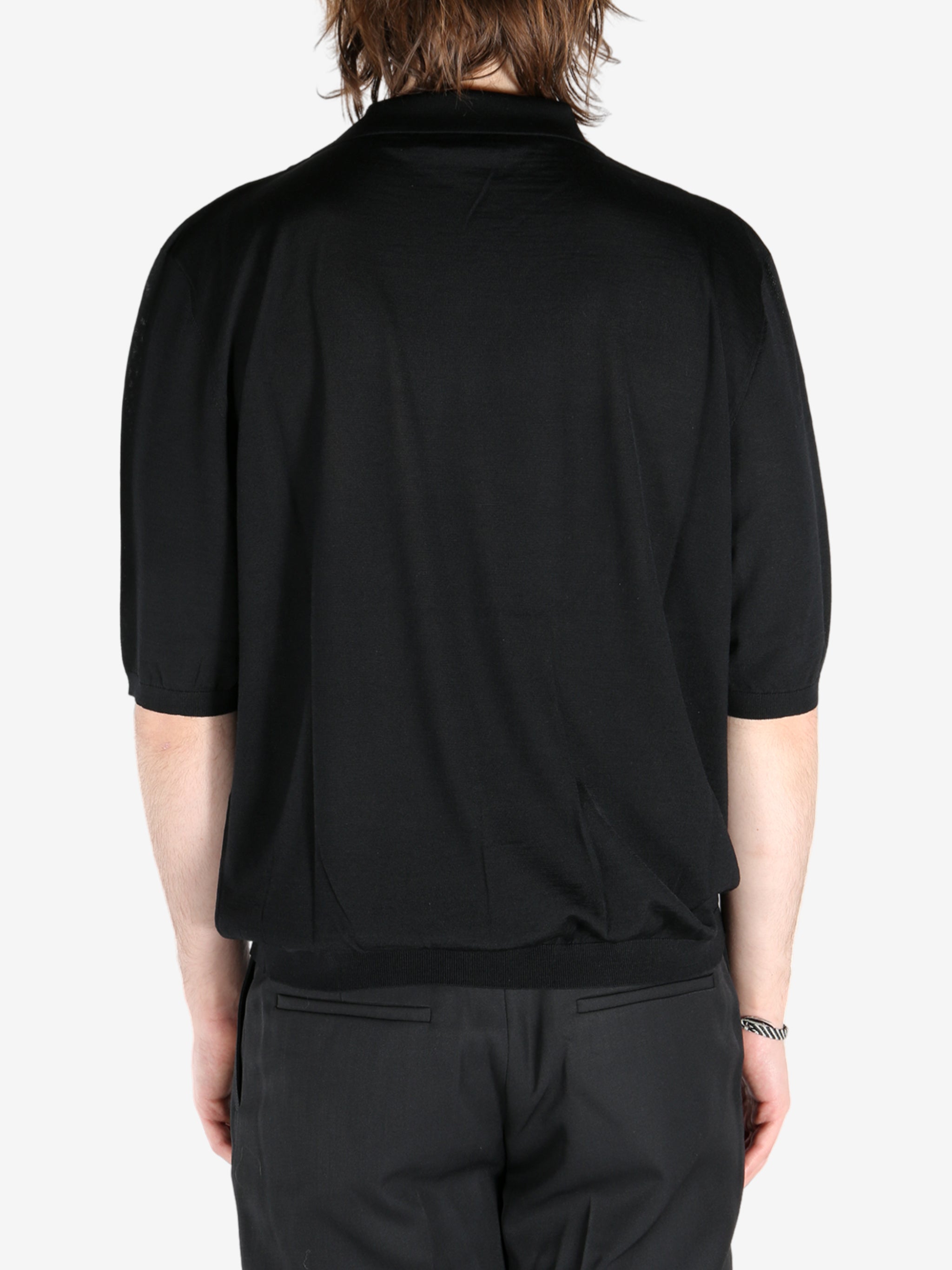 Black T-shirt worn by a person, showing the shirt’s fit