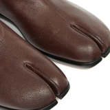 Close up of the brown shoes, showing texture of the leather fabric
