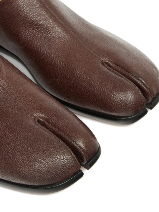 Close up of the brown shoes, showing texture of the leather fabric