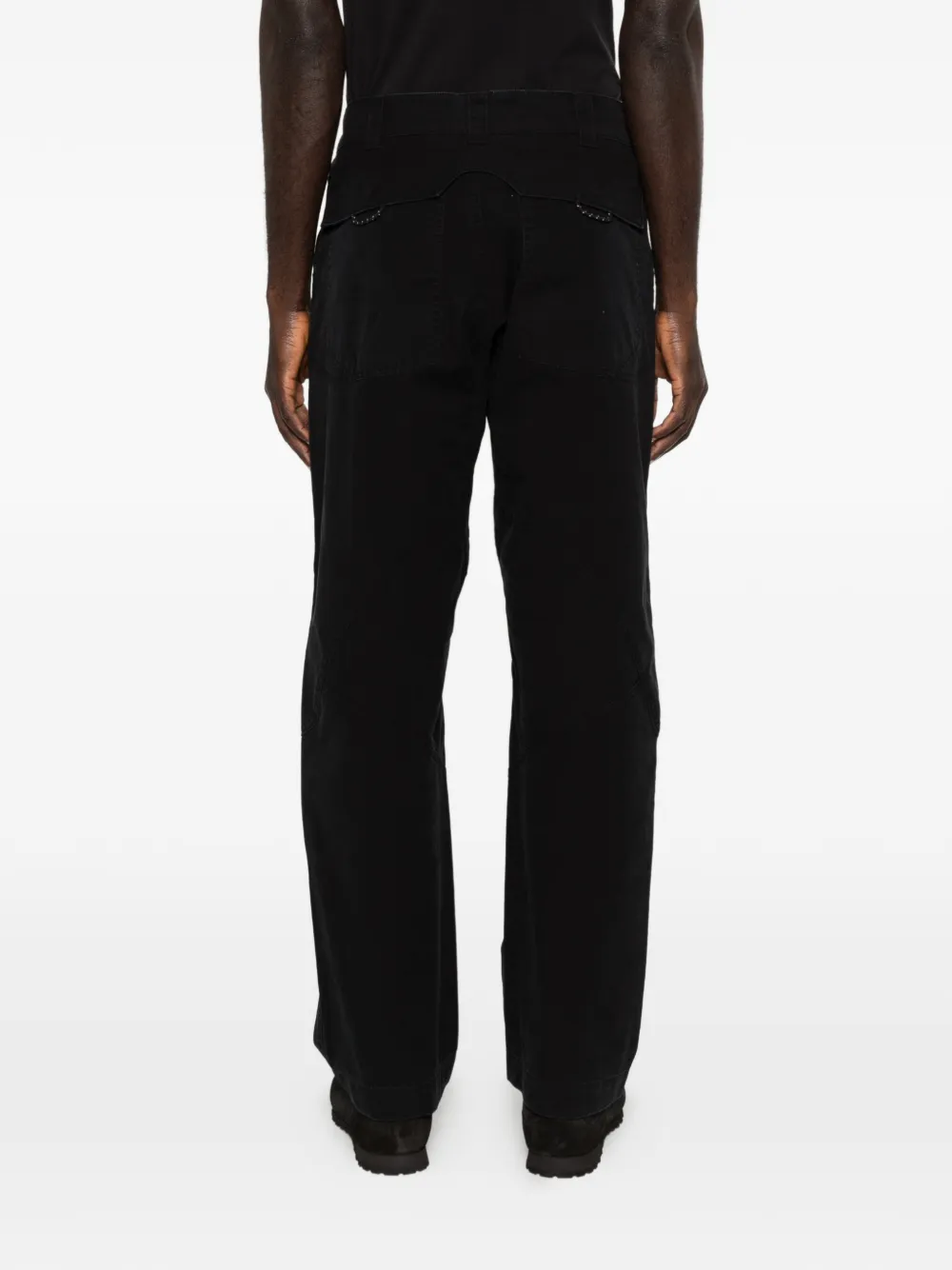 Black pants worn by a person, showing the pants fit