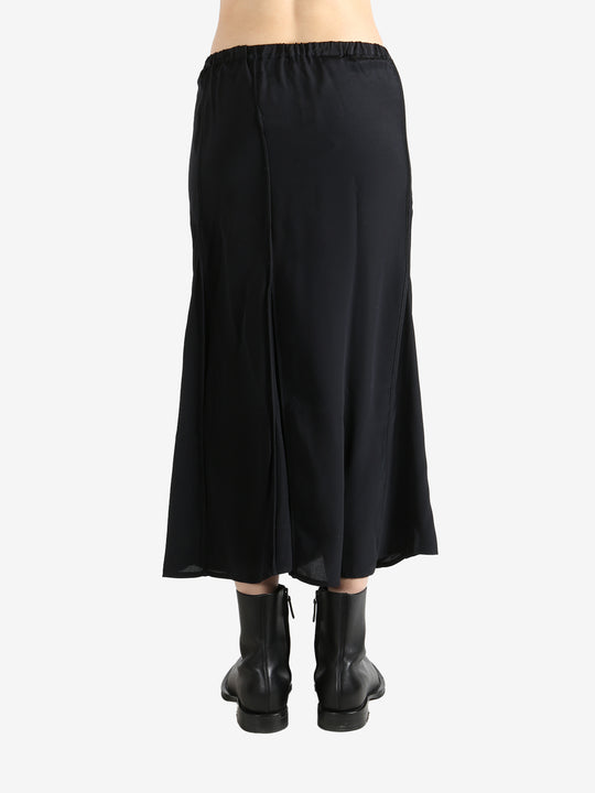 Black skirts worn by a person, showing the skirts fit
