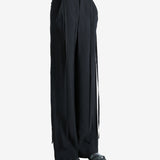 Black pants worn by a person, showing the pants' fit