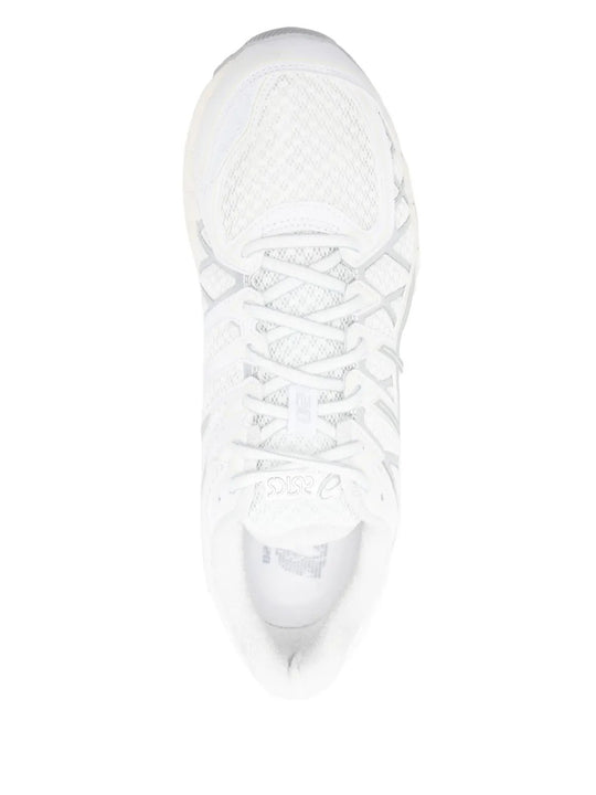 Close up of white sneakers, showing texture of the rubber and polyurethane fabric