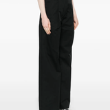 Black pant worn by a person, showing the  pant's fit