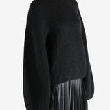 Black knitwear worn by a person, showing the knitwear fit