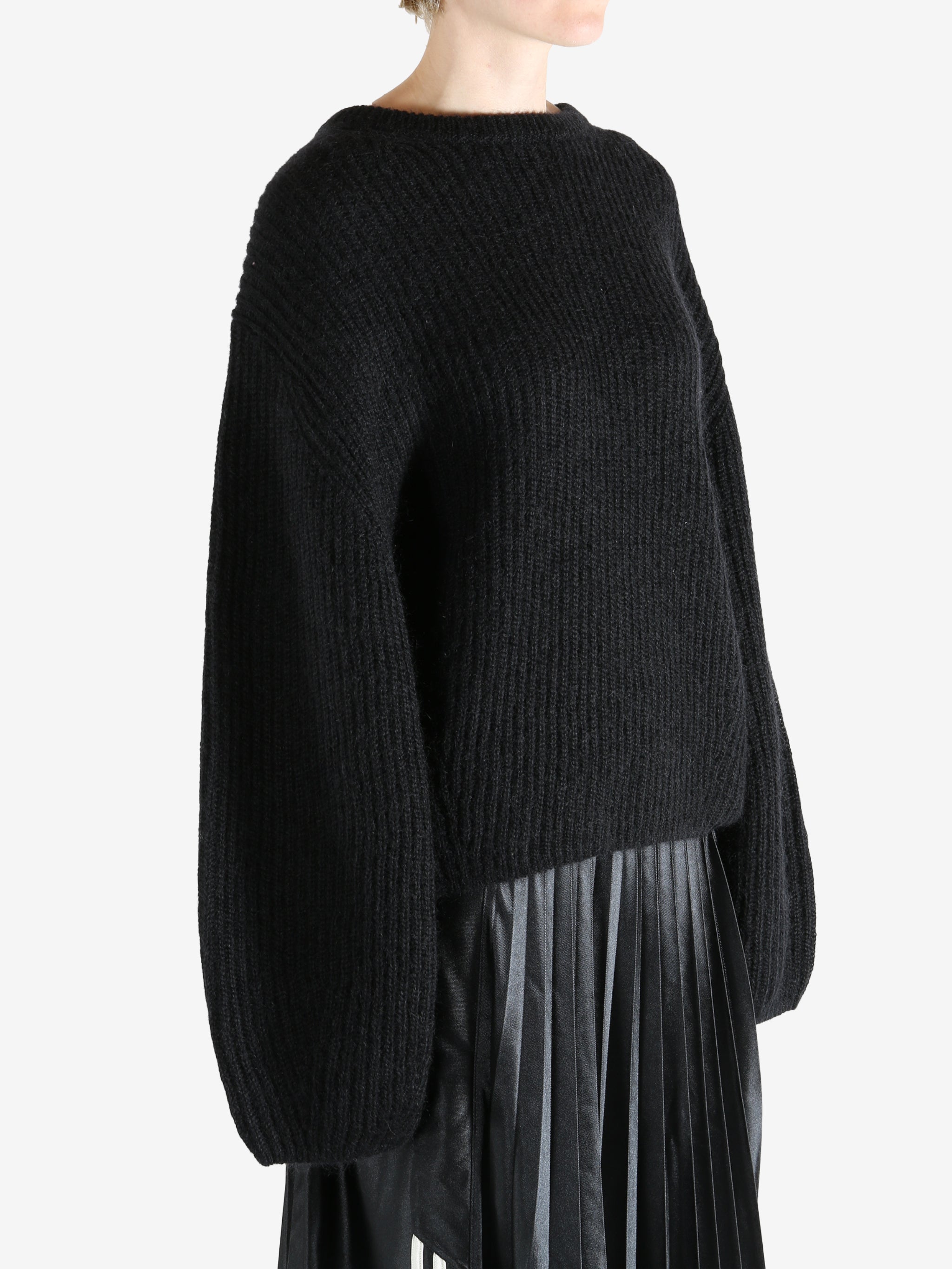 Black knitwear worn by a person, showing the knitwear fit