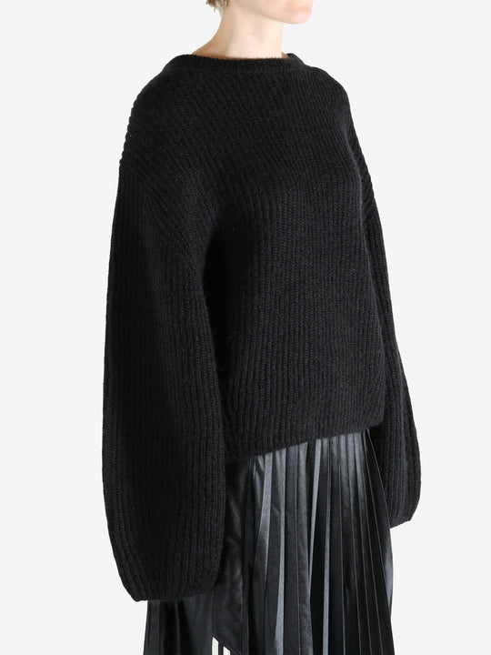 Black knitwear worn by a person, showing the knitwear fit