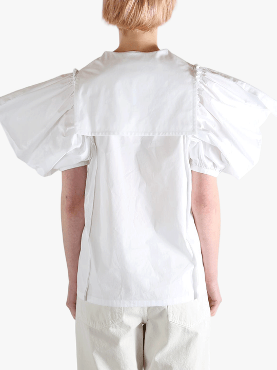 White top worn by a person, showing the top fit