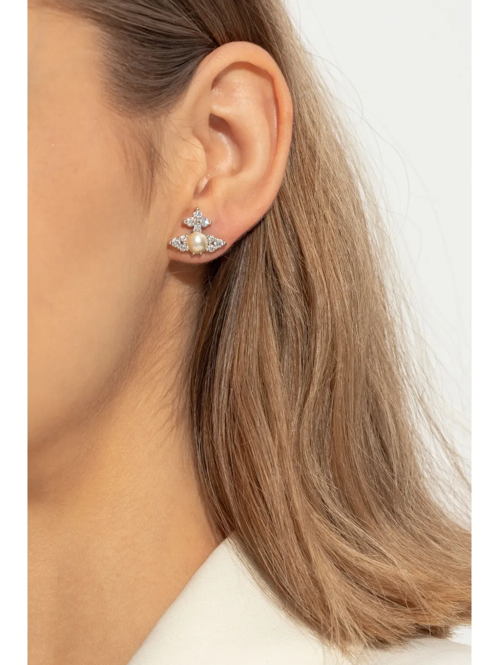 White earrings worn by a person, showing the earrings' fit