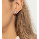 White earrings worn by a person, showing the earrings' fit