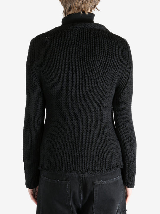 Black sweater worn by a person, showing the sweater's fit