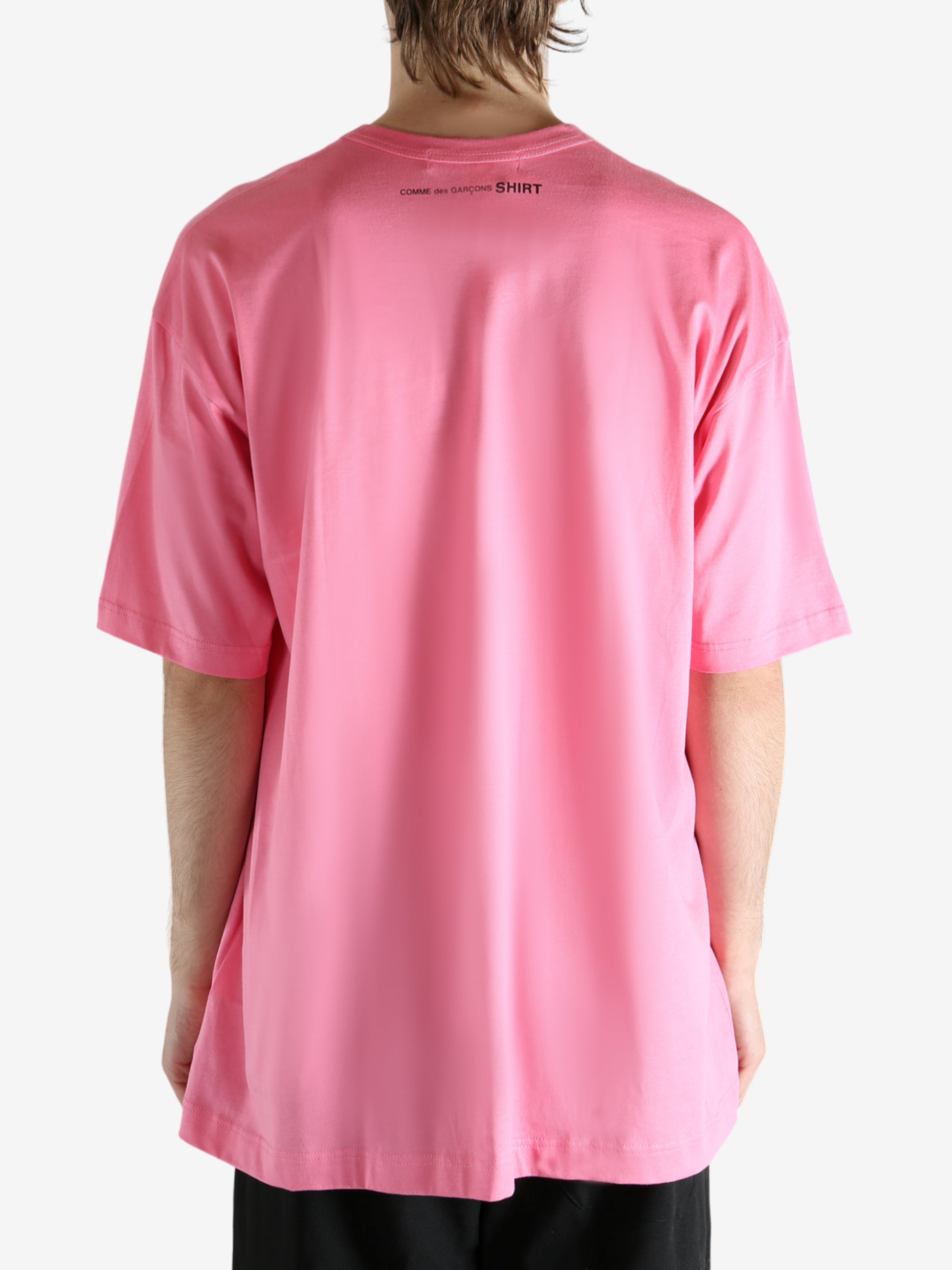 Pink t-shirt worn by a person, showing the shirt's fit