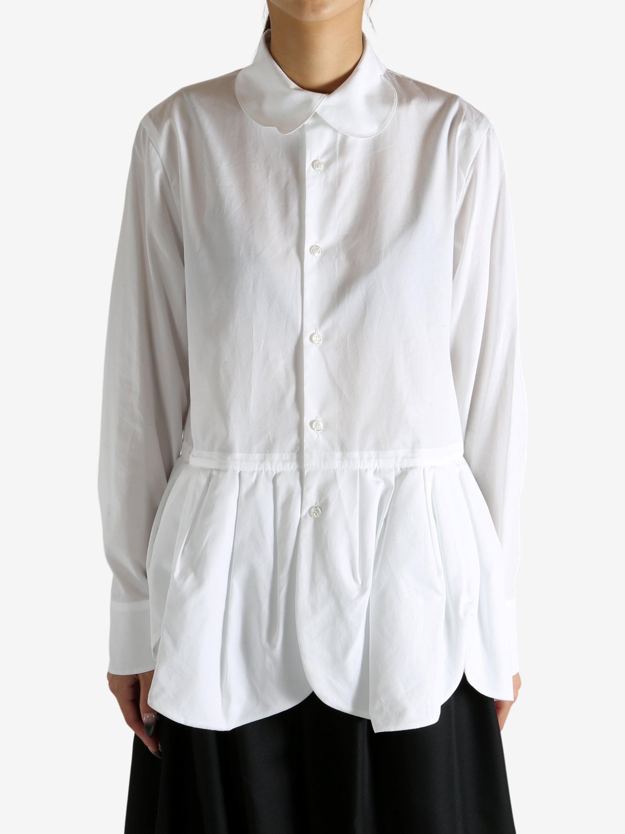 White shirt worn by a person, showing the shirt's fit