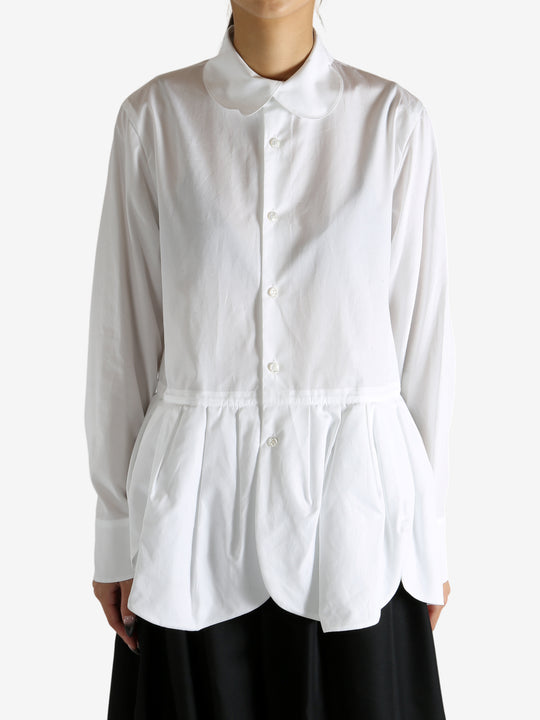 White shirt worn by a person, showing the shirt's fit