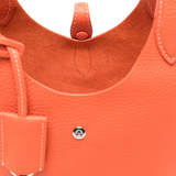 Close up of orange bag, showing texture of the calf leather fabric
