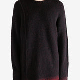 Black knitwear worn by a person, showing the knitwear's fit