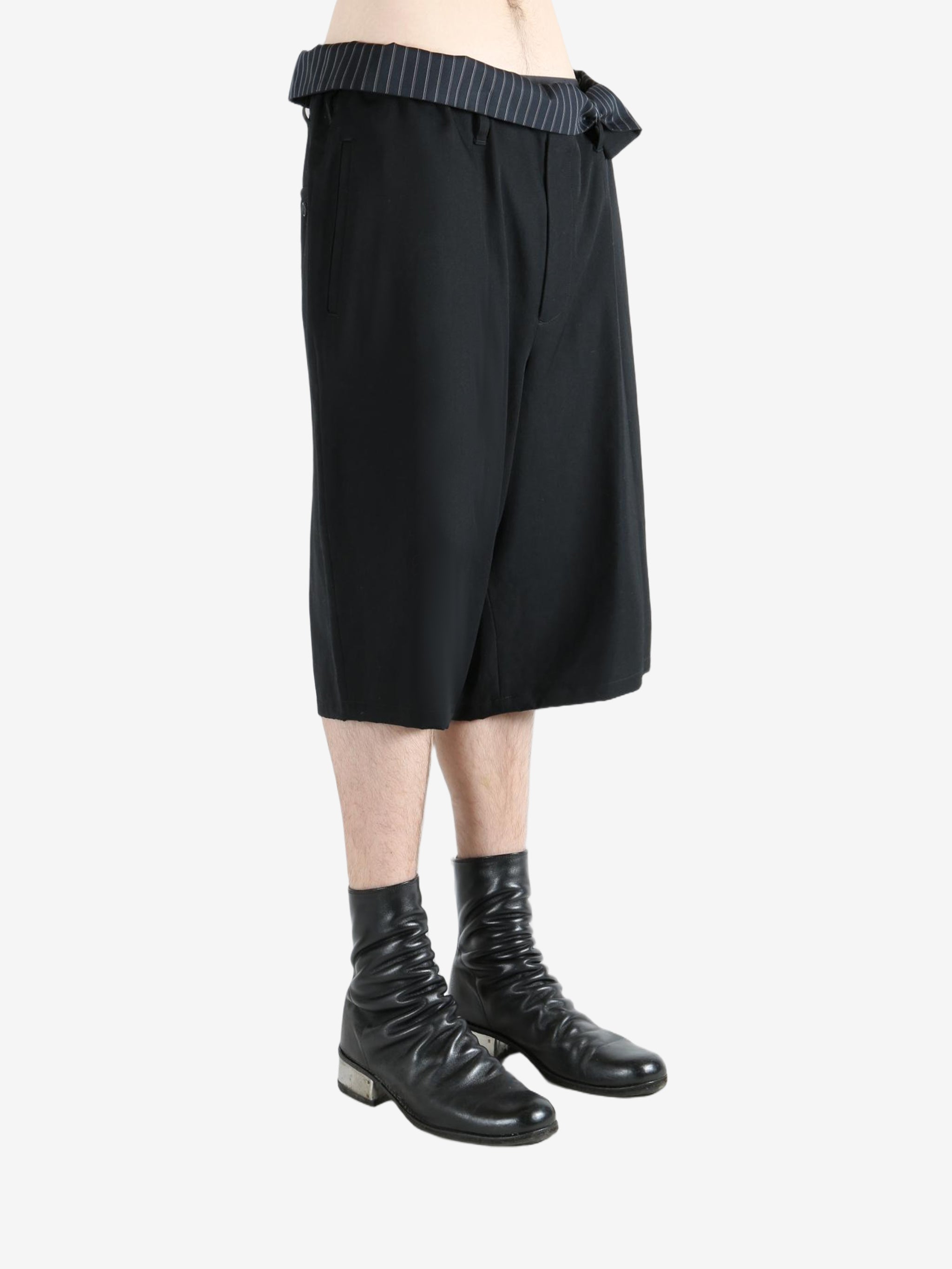 Black pants worn by a person, showing the pants's fit