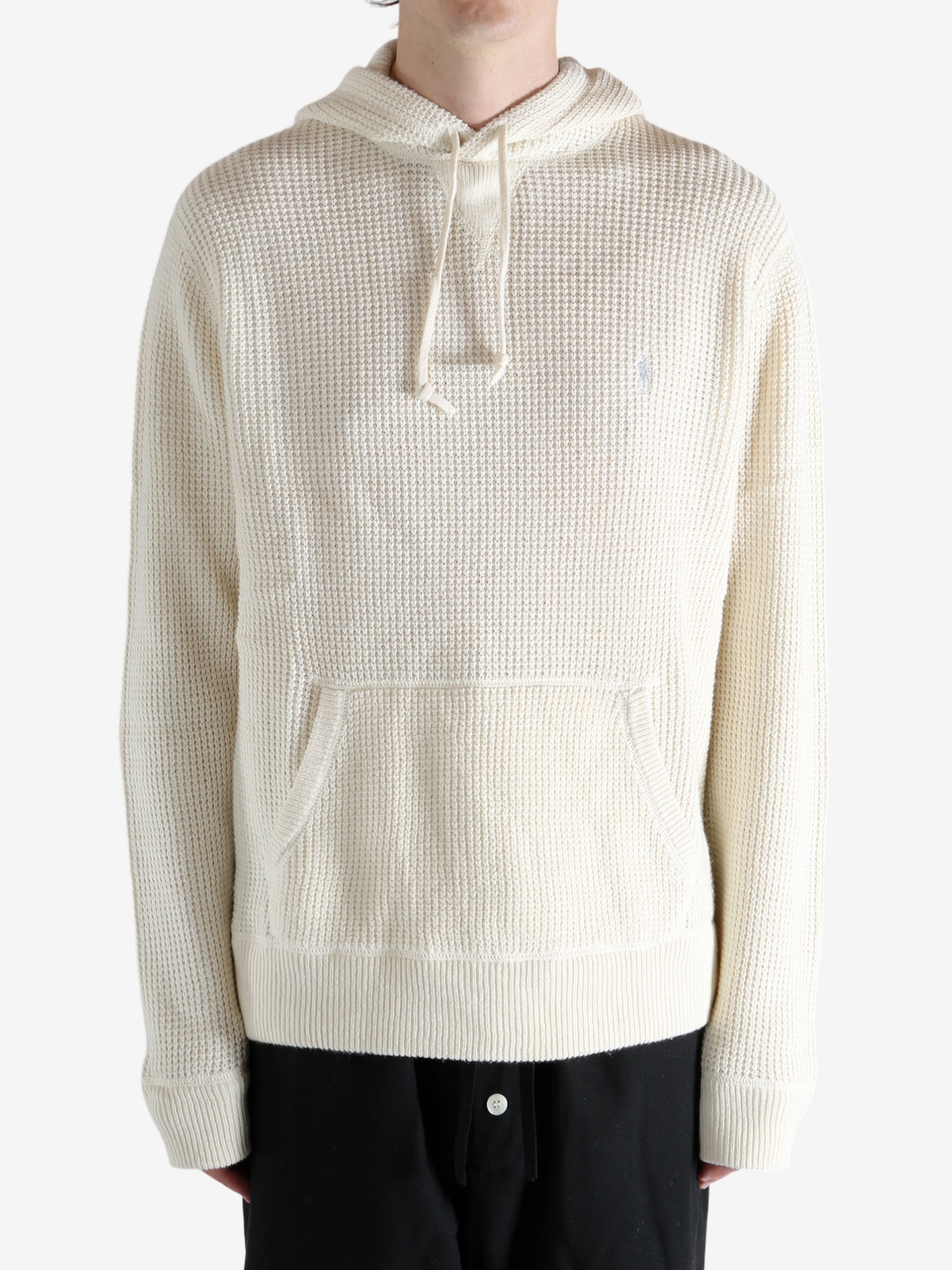 White knitwear worn by a person, showing the knitwear's fit