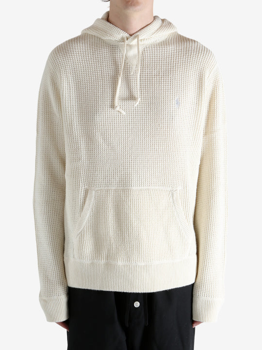 White knitwear worn by a person, showing the knitwear's fit