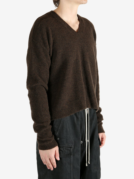 Brown knitwear worn by a person, showing the knitwear's fit