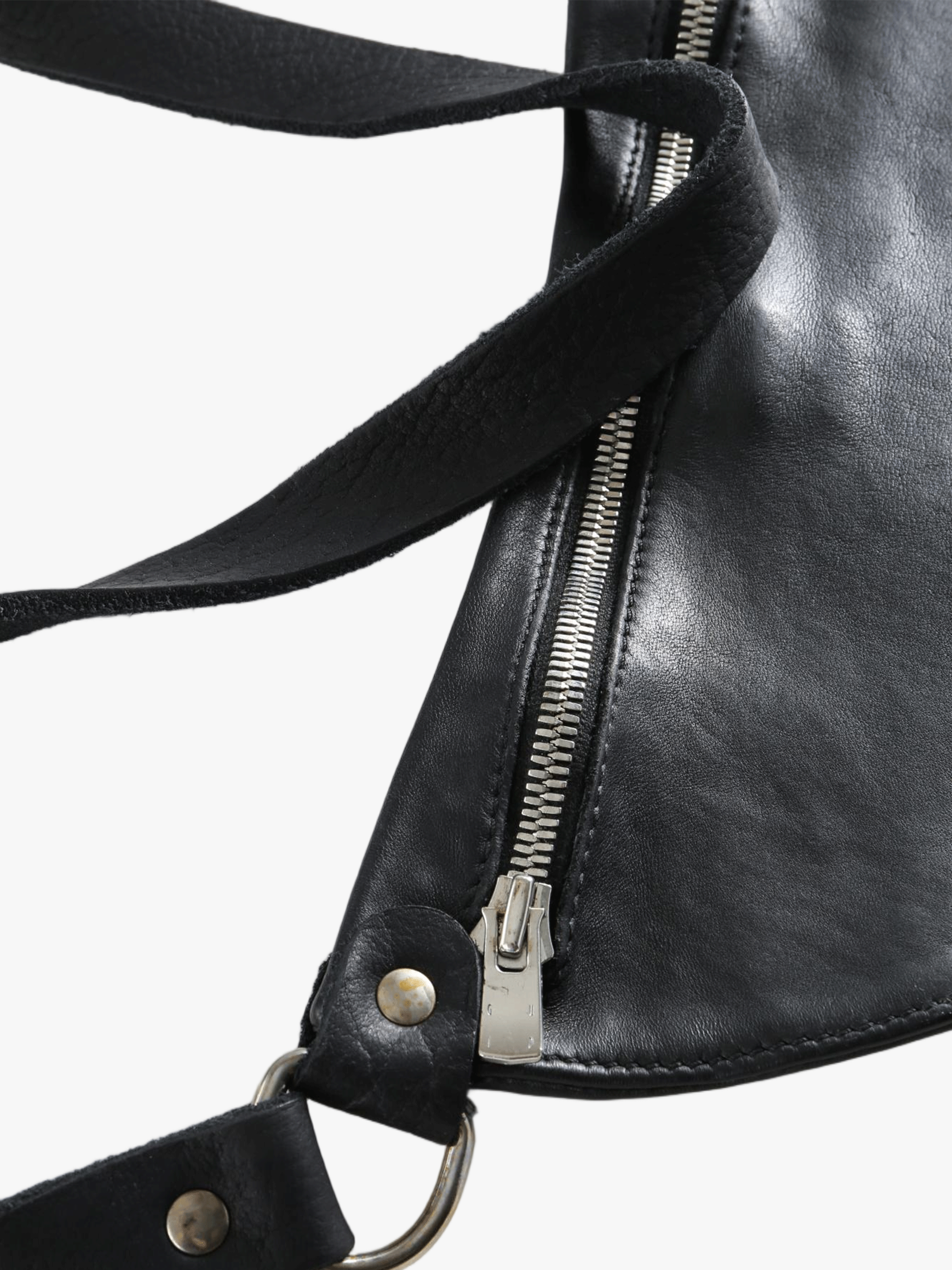 Close-up of a black leather bag with a zipper and strap details on a white background
