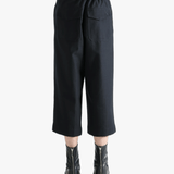 Black pants worn by a person, showing the pants's fit