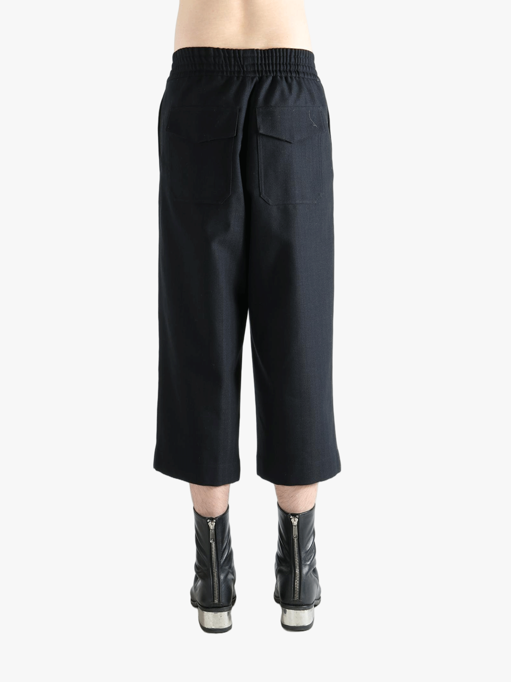 Black pants worn by a person, showing the pants's fit