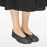 Black flat worn by a person, showing the flat's fit