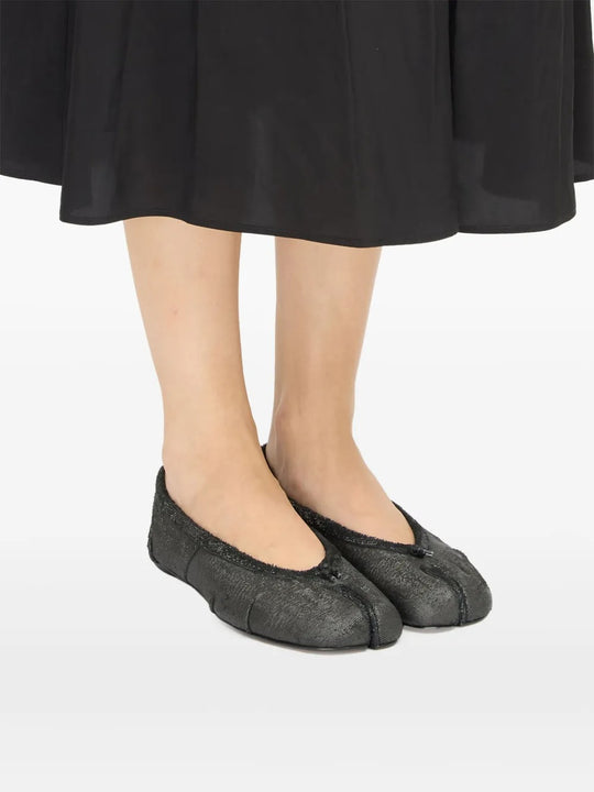 Black flat worn by a person, showing the flat's fit