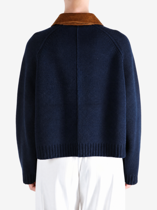 Navy knitwear worn by a person, showing the knitwear fit