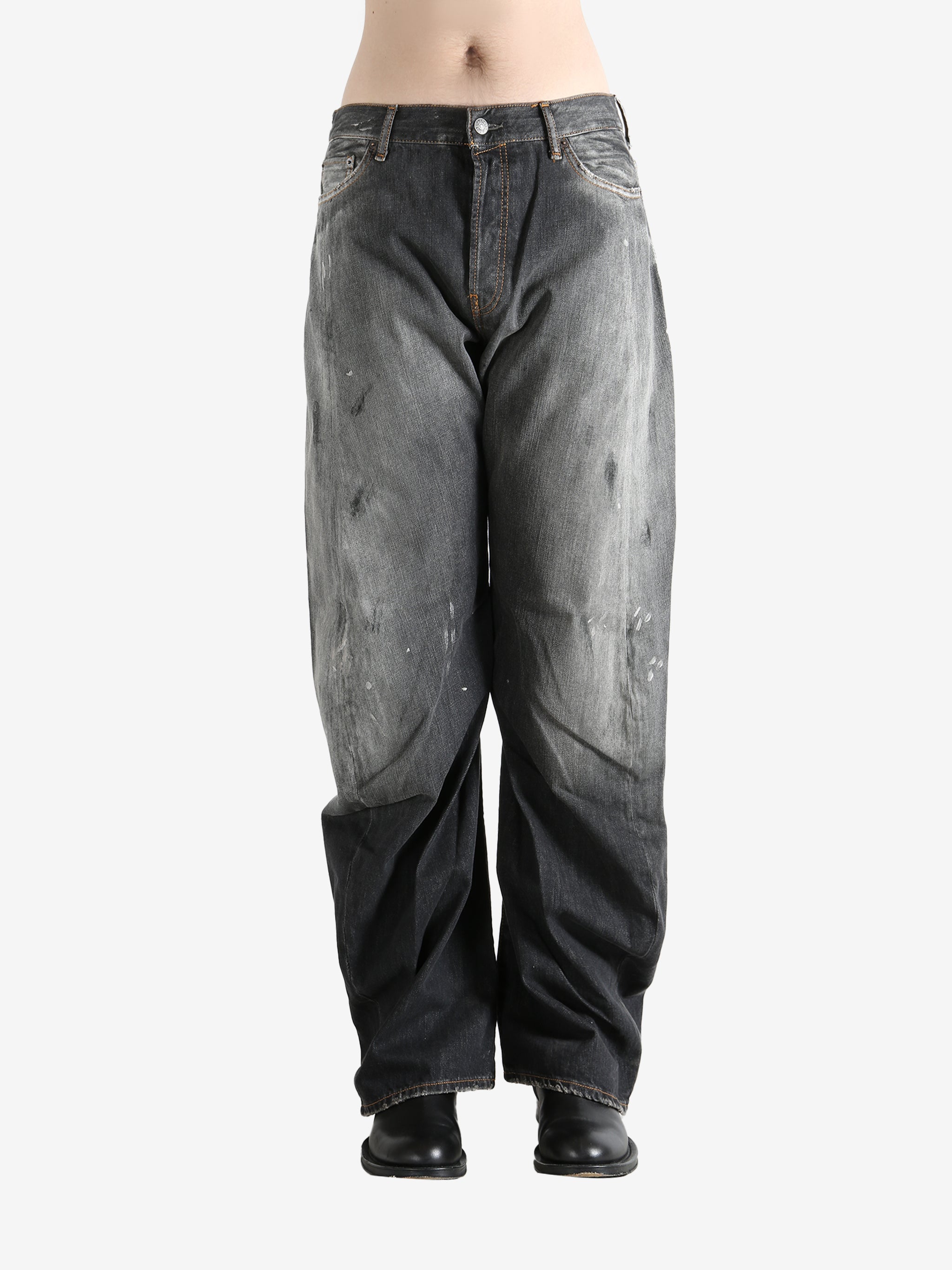 Black jeans worn by a person, showing the jeans fit