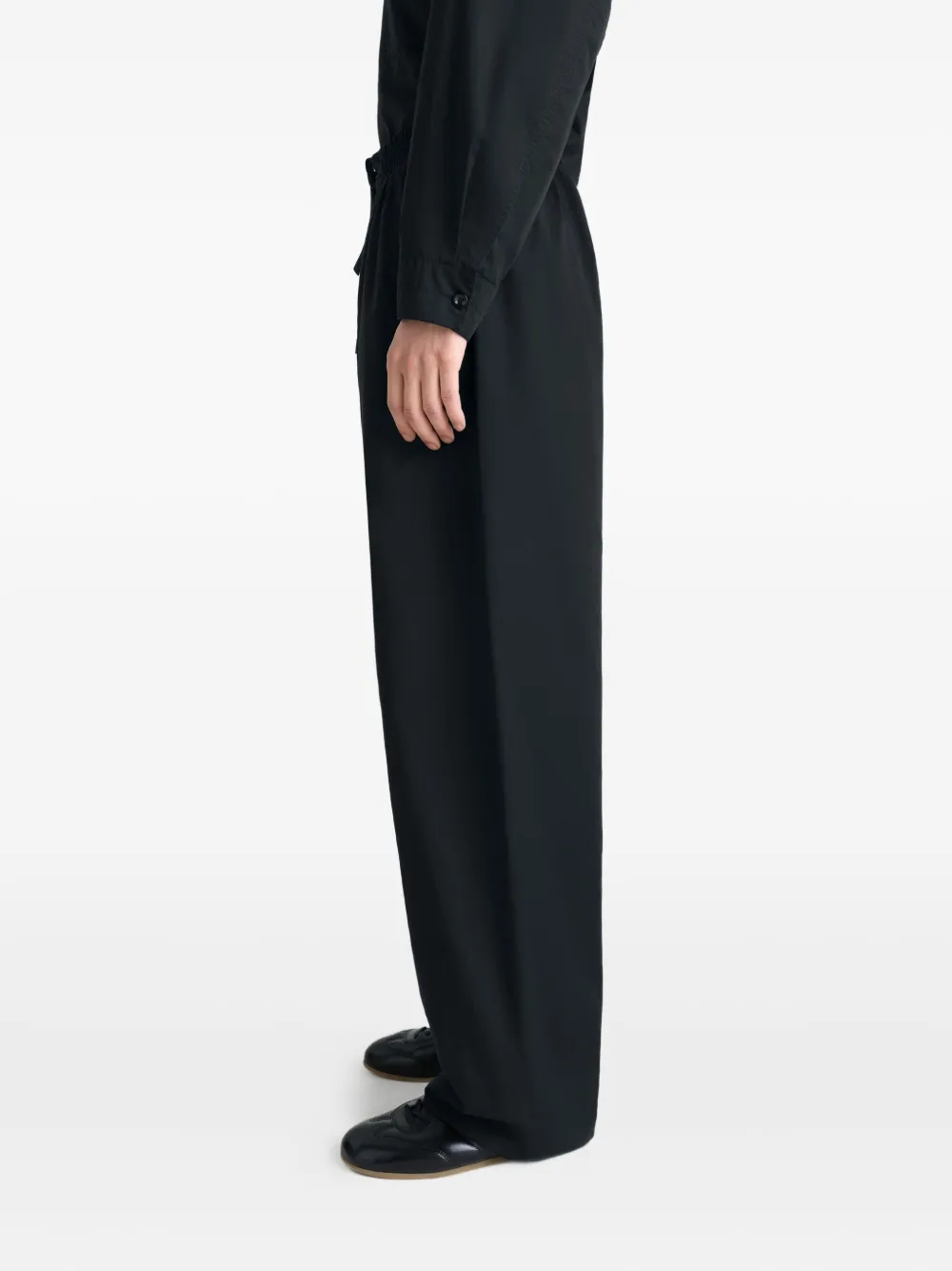 black pants worn by a person, showing the pants fit