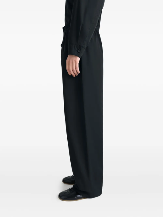 black pants worn by a person, showing the pants fit