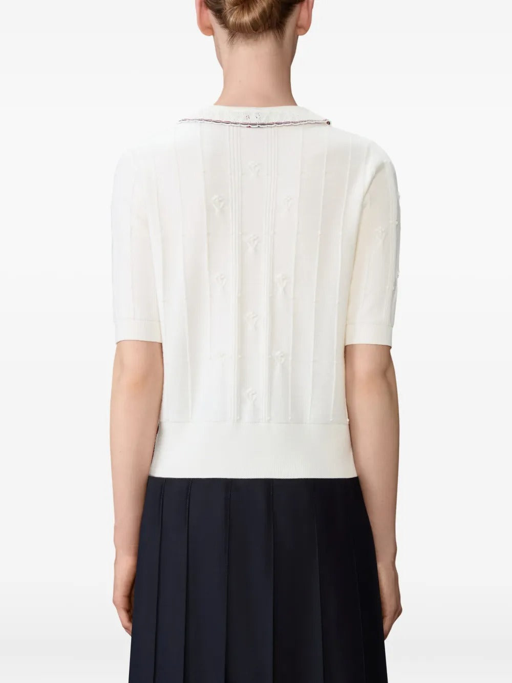 White knitwear worn by a person, showing the knitwear's fit