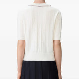 White knitwear worn by a person, showing the knitwear's fit